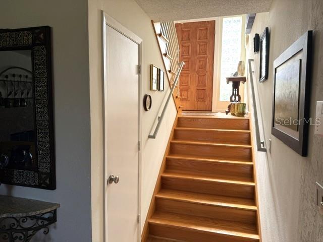 A staircase with wooden steps leads up to a front door in a residential entryway — 609 42ND STREET COURT W, PALMETTO, FL