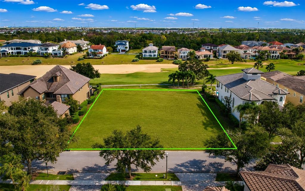 An aerial view shows a vacant, rectangular residential lot outlined in green between two houses — 365 MUIRFIELD LOOP, KISSIMMEE, FL