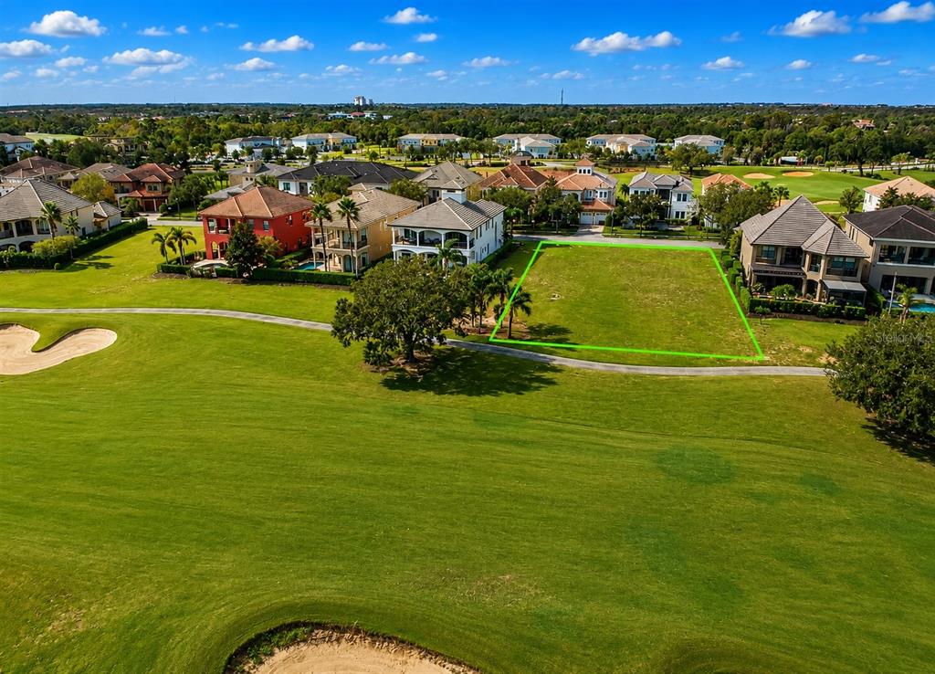 An aerial view shows a vacant residential lot outlined in green on a golf course — 365 MUIRFIELD LOOP, KISSIMMEE, FL