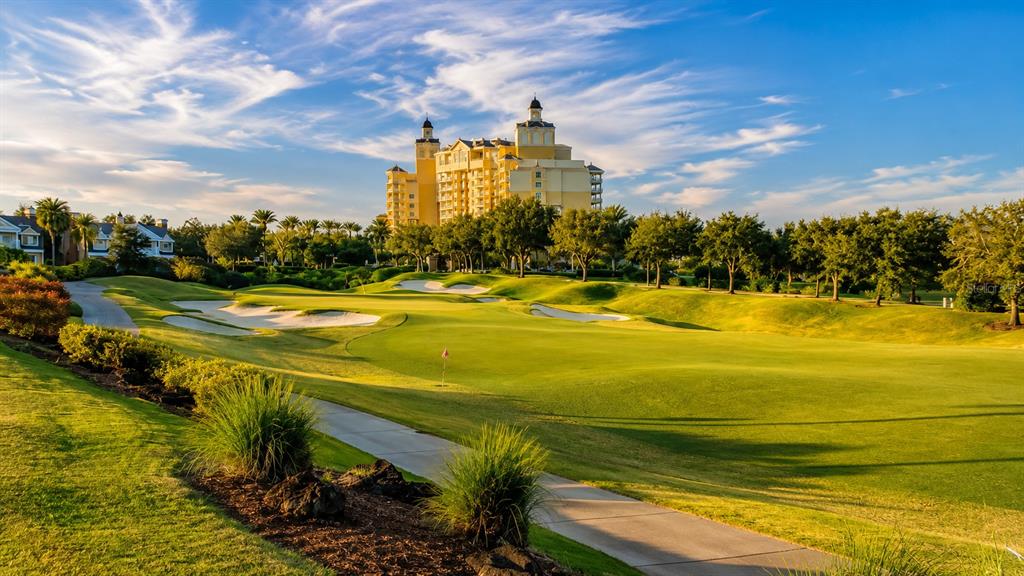A golf course fairway leads toward a large multi-story resort building under a blue sky — 365 MUIRFIELD LOOP, KISSIMMEE, FL
