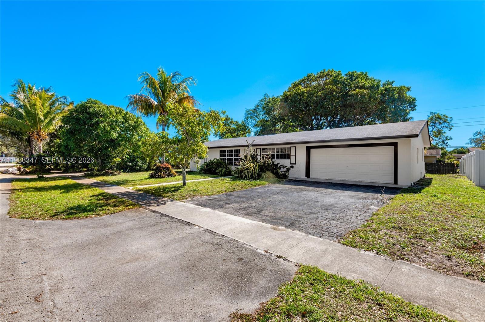 A single-story house with a white exterior, a dark roof, and an attached garage — 4360 NW 4th St, Plantation FL 33317, PLANTATION, FL