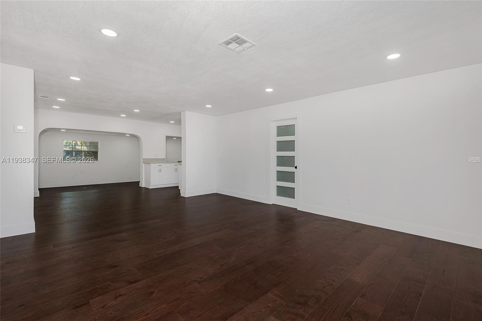 A spacious room features dark wood flooring, white walls, recessed lighting, and a frosted glass door — 4360 NW 4th St, Plantation FL 33317, PLANTATION, FL