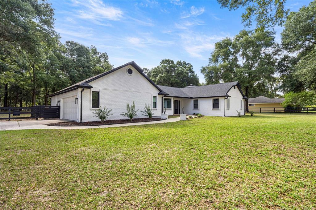 A rectangular swimming pool sits on a concrete patio in front of a grassy yard — 3251 SW 56TH AVENUE, OCALA, FL