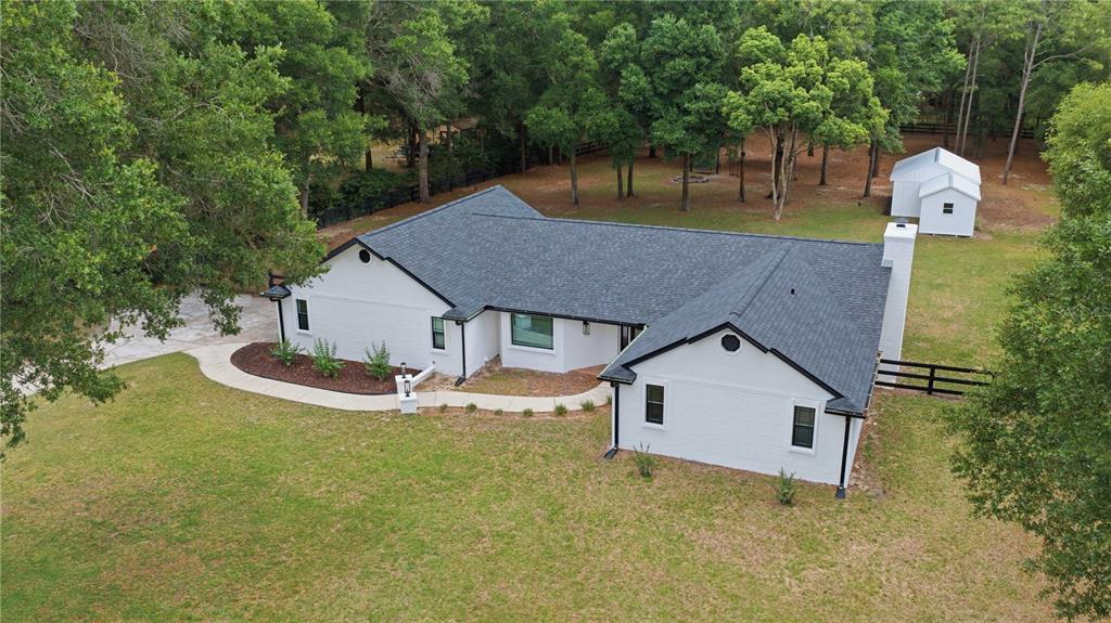 An aerial view of a white brick house with a dark roof and black trim — 3251 SW 56TH AVENUE, OCALA, FL