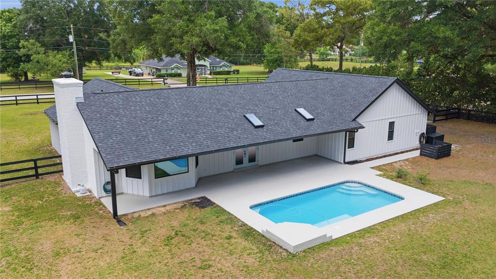 An aerial view shows a residential property with a house, driveway, and trees outlined in white — 3251 SW 56TH AVENUE, OCALA, FL