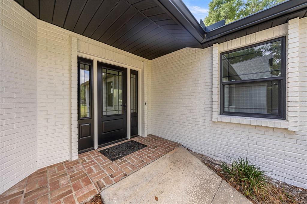 An aerial view shows a white house with a dark roof surrounded by mature trees — 3251 SW 56TH AVENUE, OCALA, FL