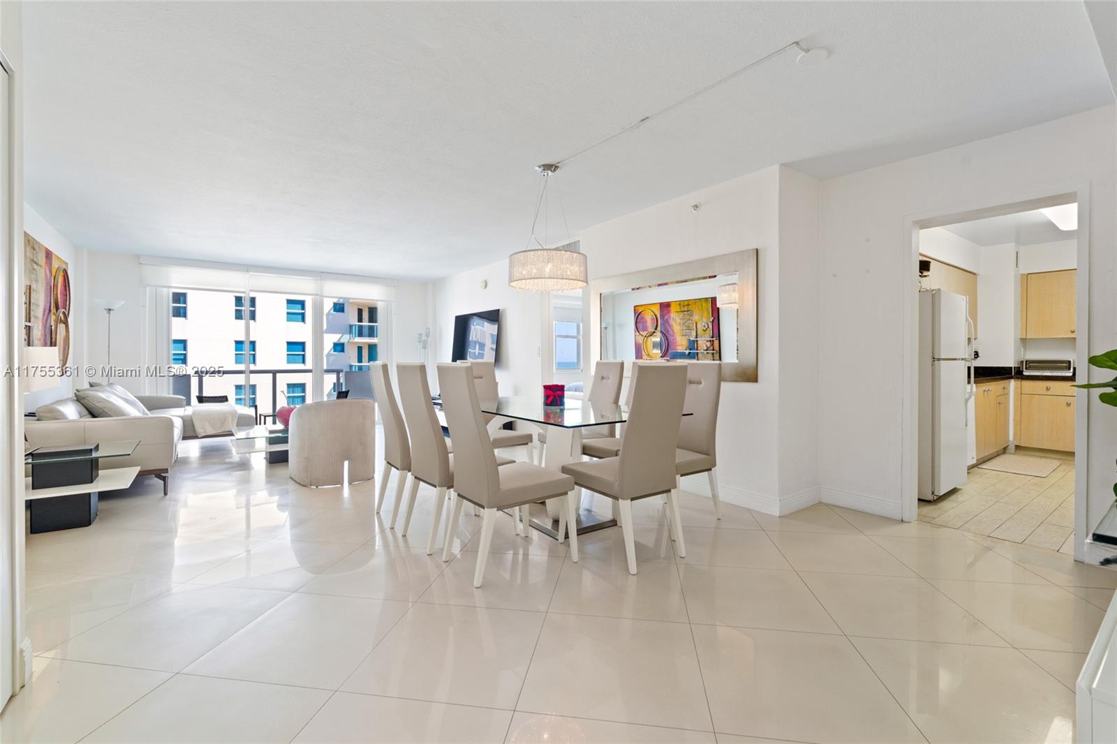 An open-concept living and dining area features light tile floors and a glass-top table — 9195 Collins Ave # 1103, Surfside FL 33154, SURFSIDE, FL