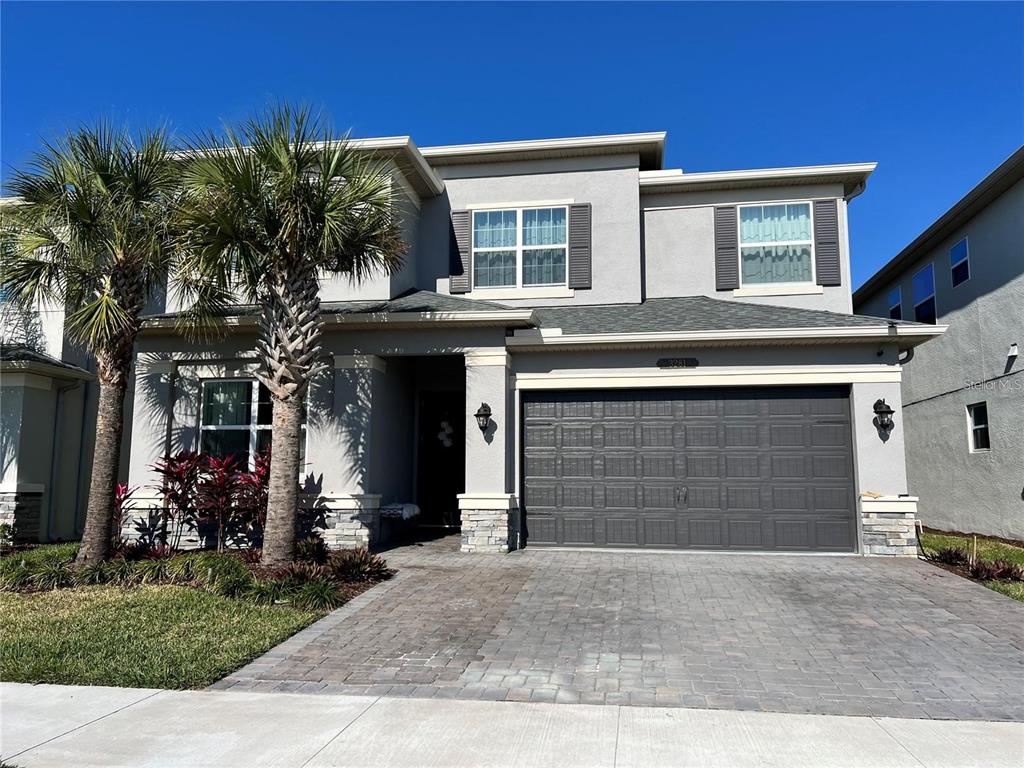 A two-story house with a gray stucco exterior, a two-car garage, and palm trees — 3281 GREAT BANYAN WAY, WESLEY CHAPEL, FL