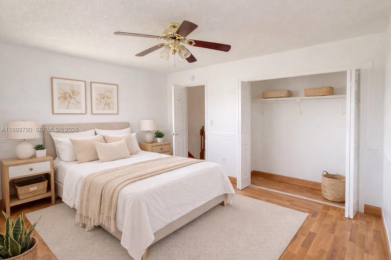 A bedroom features a bed, ceiling fan, closet, and light-colored wood flooring — 1283 W 51st Place # 12, Hialeah FL 33012, HIALEAH, FL