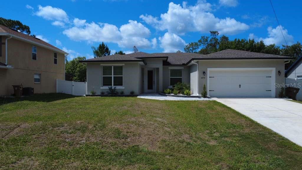 A single-story house with a light gray exterior, a two-car garage, and a front lawn — 6370 BENNETT COURT, ST CLOUD, FL