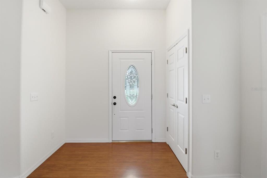 An entryway features white walls, a wood floor, a white front door, and a closet — 6347 N MYAKA AVENUE, CRYSTAL RIVER, FL