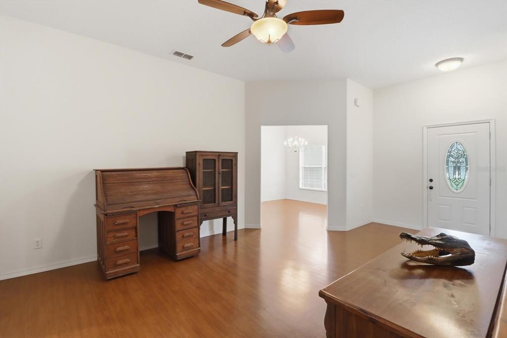 A room with wood flooring, a roll-top desk, a cabinet, and an alligator head decoration — 6347 N MYAKA AVENUE, CRYSTAL RIVER, FL
