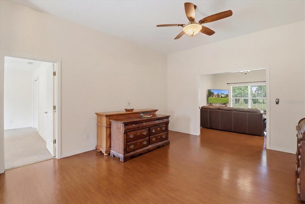 A room with wood flooring, a ceiling fan, and two wooden dressers against a wall — 6347 N MYAKA AVENUE, CRYSTAL RIVER, FL