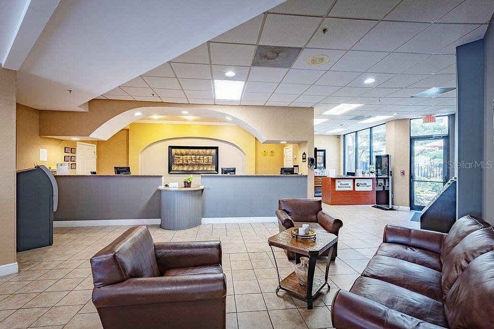 A hotel lobby features a reception desk, leather seating, and tiled flooring — 6165 CARRIER DR DRIVE UNIT 1114, ORLANDO, FL