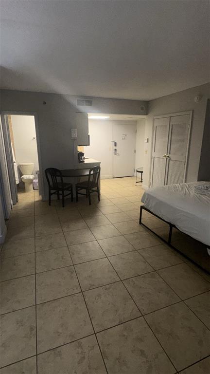 A hotel room featuring a bed, a small dining table, a kitchenette, and a bathroom — 6165 CARRIER DR DRIVE UNIT 1114, ORLANDO, FL