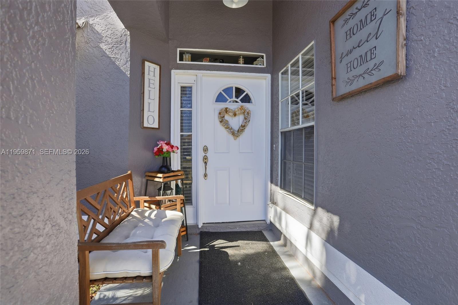 A front porch features a white door with a heart wreath and a wooden bench — 12608 Crayford ave, Orlando FL 32837, ORLANDO, FL