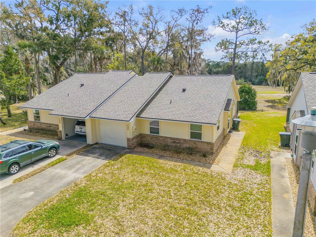 An aerial view of a single-story duplex with a tan exterior, stone accents, and garages — 240 BOB WHITE COURT UNIT 240, DAYTONA BEACH, FL