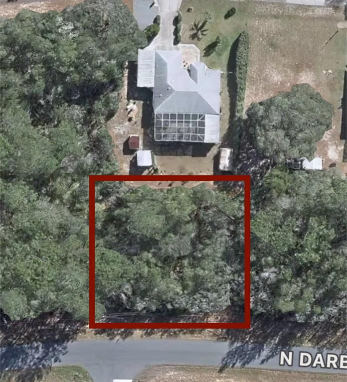 This aerial view shows a residential property with a house and a wooded lot — 7891 N DARBY DRIVE, CITRUS SPRINGS, FL