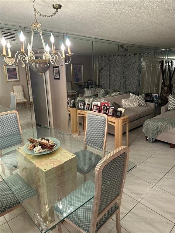 A dining area with a glass table and chairs sits before a mirrored living room — 2671 S Course Drive S # 108, Pompano Beach FL 33069, POMPANO BEACH, FL