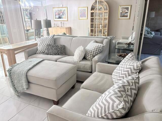 A living room features light-colored sofas, a matching ottoman, and chevron-patterned throw pillows — 2671 S Course Drive S # 108, Pompano Beach FL 33069, POMPANO BEACH, FL