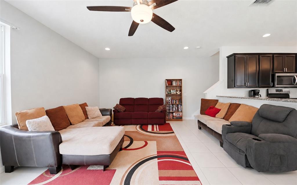 A two-story tan house with a two-car garage and a paved driveway — 1136 E 10TH STREET, APOPKA, FL