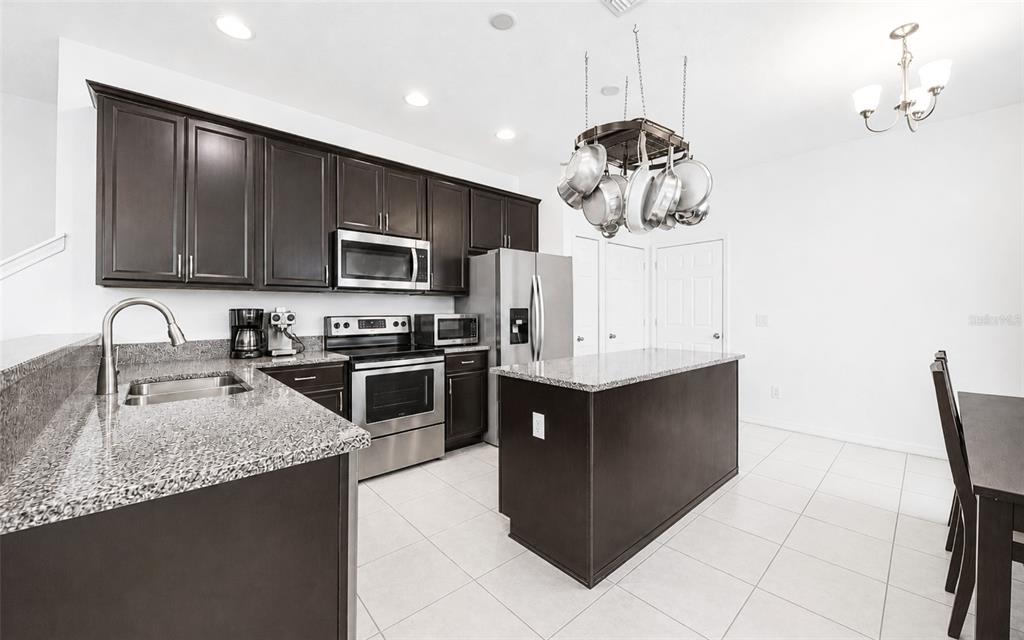 A living room features a ceiling fan, a television, a sectional sofa, and a sliding door — 1136 E 10TH STREET, APOPKA, FL