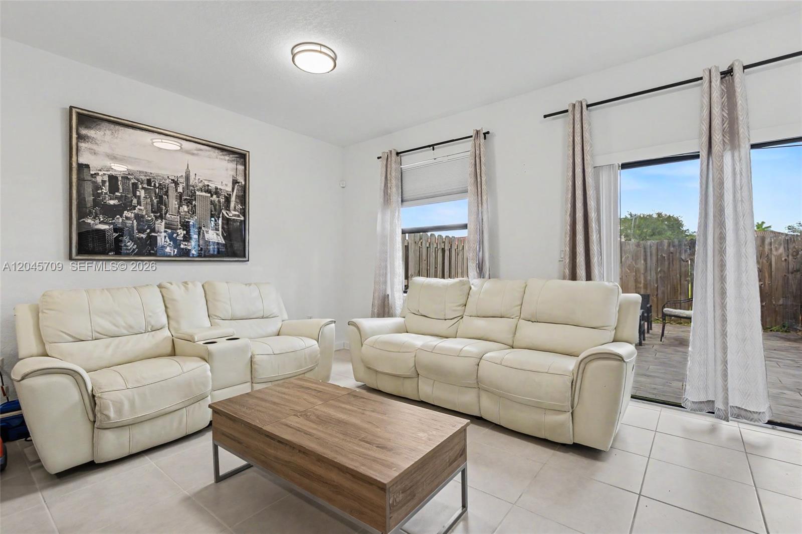 A living room features two white leather sofas, a wooden coffee table, and sliding doors — 18102 SW 148th Rd, Miami FL 33187, MIAMI, FL