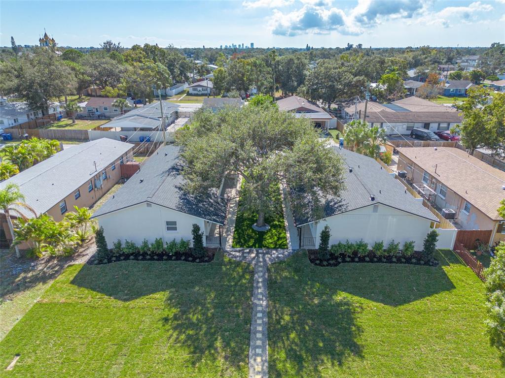 An aerial view shows two white houses separated by a central courtyard with a large tree — 544 93RD AVENUE N, ST PETERSBURG, FL