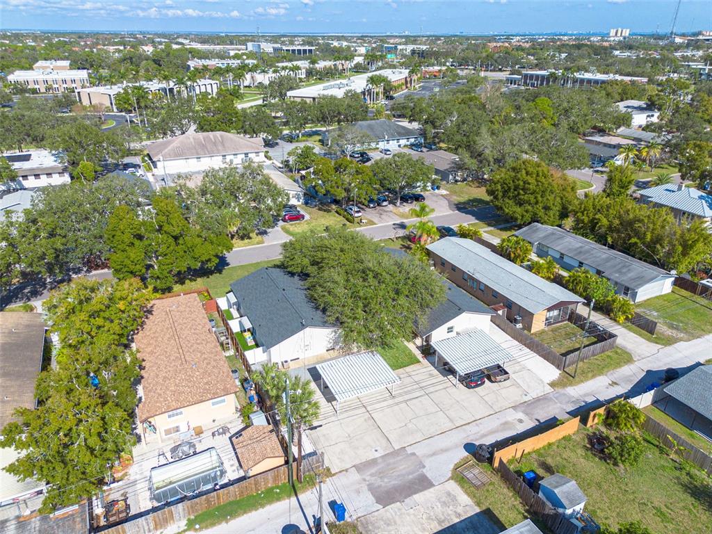 An aerial view shows a residential property with two adjacent buildings, carports, and surrounding trees — 544 93RD AVENUE N, ST PETERSBURG, FL