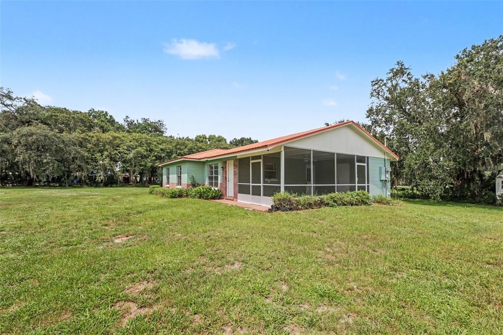 A single-story house with a screened-in porch sits on a large, grassy lot — 3149 SYDNEY DOVER ROAD, DOVER, FL