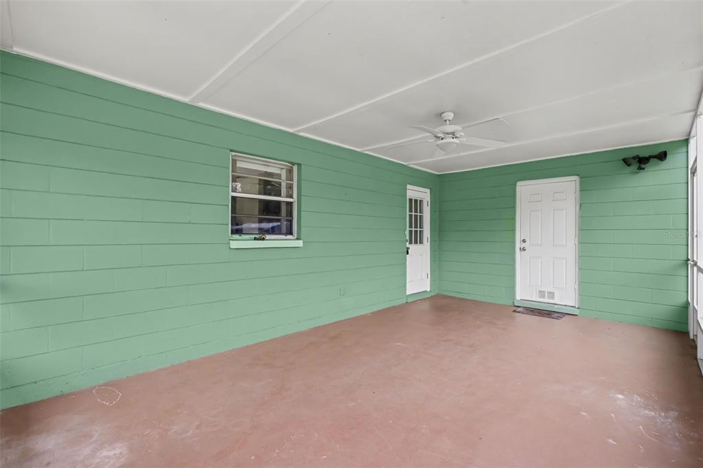 A covered porch with green block walls, a concrete floor, and two white doors — 3149 SYDNEY DOVER ROAD, DOVER, FL