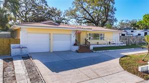 A yellow single-story house with a two-car garage and a concrete driveway — 1201 KAPOK KOVE CIRCLE, CLEARWATER, FL