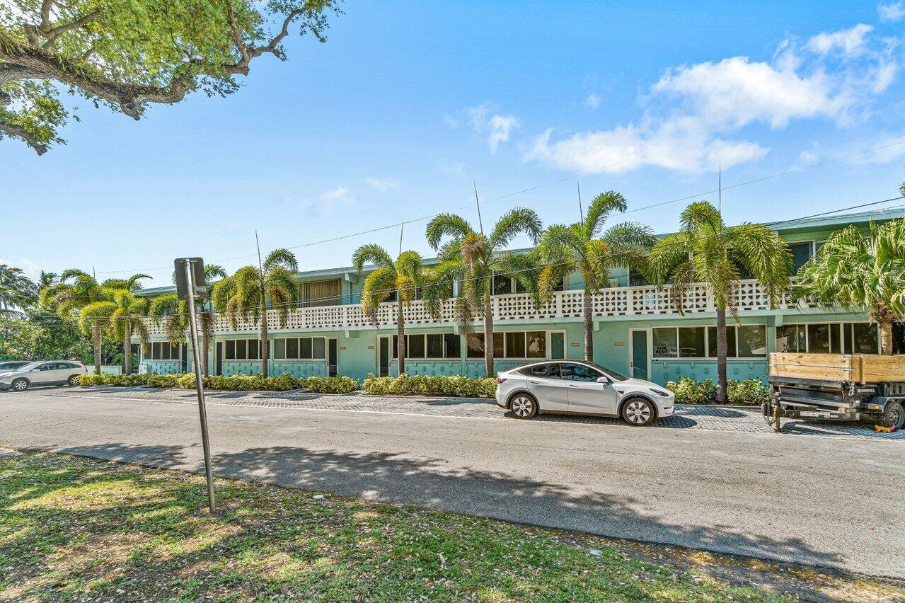 A two-story light green apartment building with palm trees and a parked white sedan — 65 SE Spanish Trail # 2020, Boca Raton FL 33432, BOCA RATON, FL
