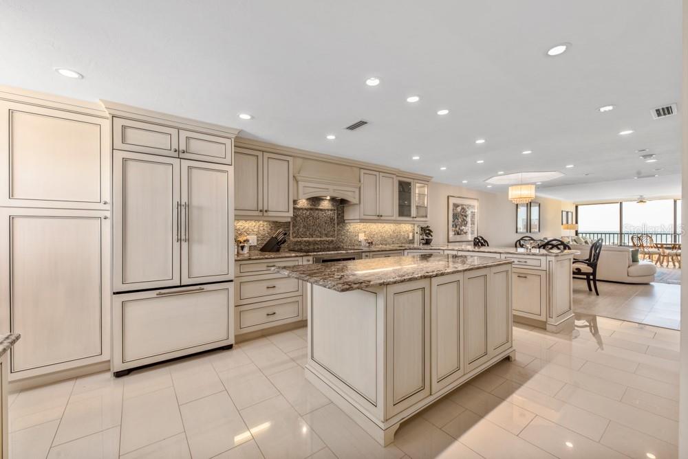 A kitchen with cream-colored cabinetry, a granite-topped island, and light tile flooring — 5770 MIDNIGHT PASS ROAD UNIT 605, SARASOTA, FL