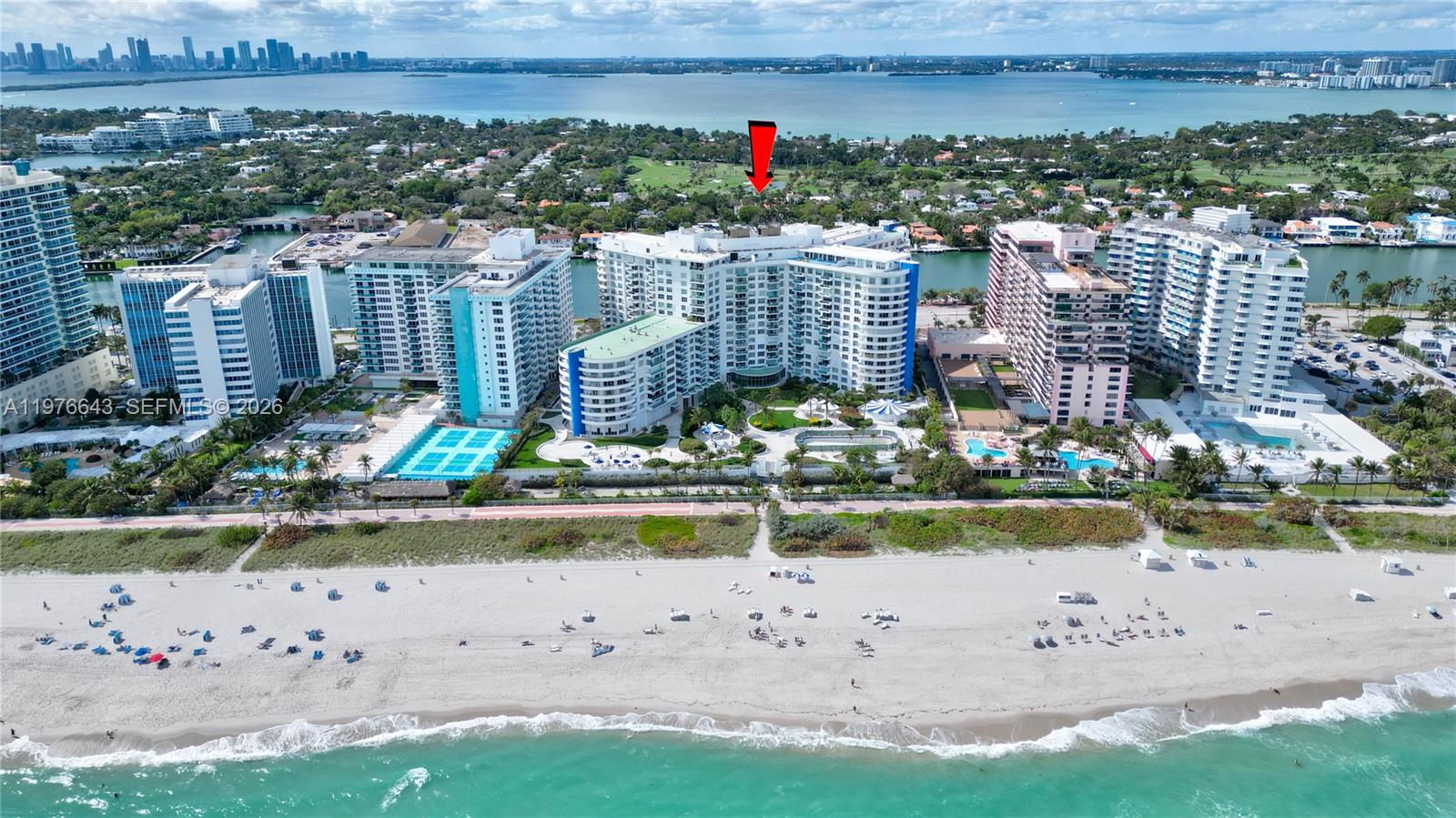 An aerial view shows several high-rise residential buildings situated directly along a sandy beach — 5161 Collins Ave # 516, Miami Beach FL 33140, MIAMI BEACH, FL