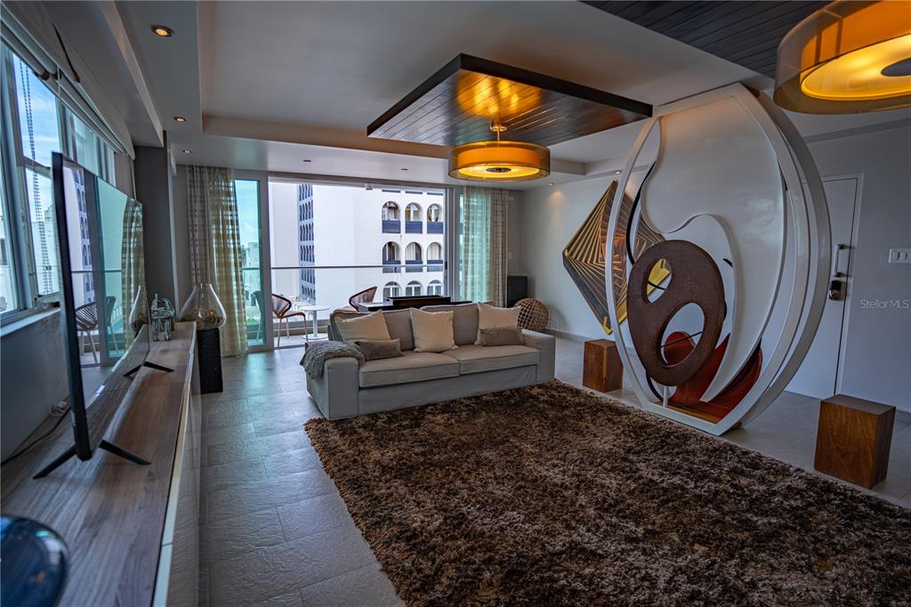 A modern living room features a plush brown rug, a gray sofa, and sculptural decor — 1124 ASHFORD AVENUE UNIT 5B, SAN JUAN, PR
