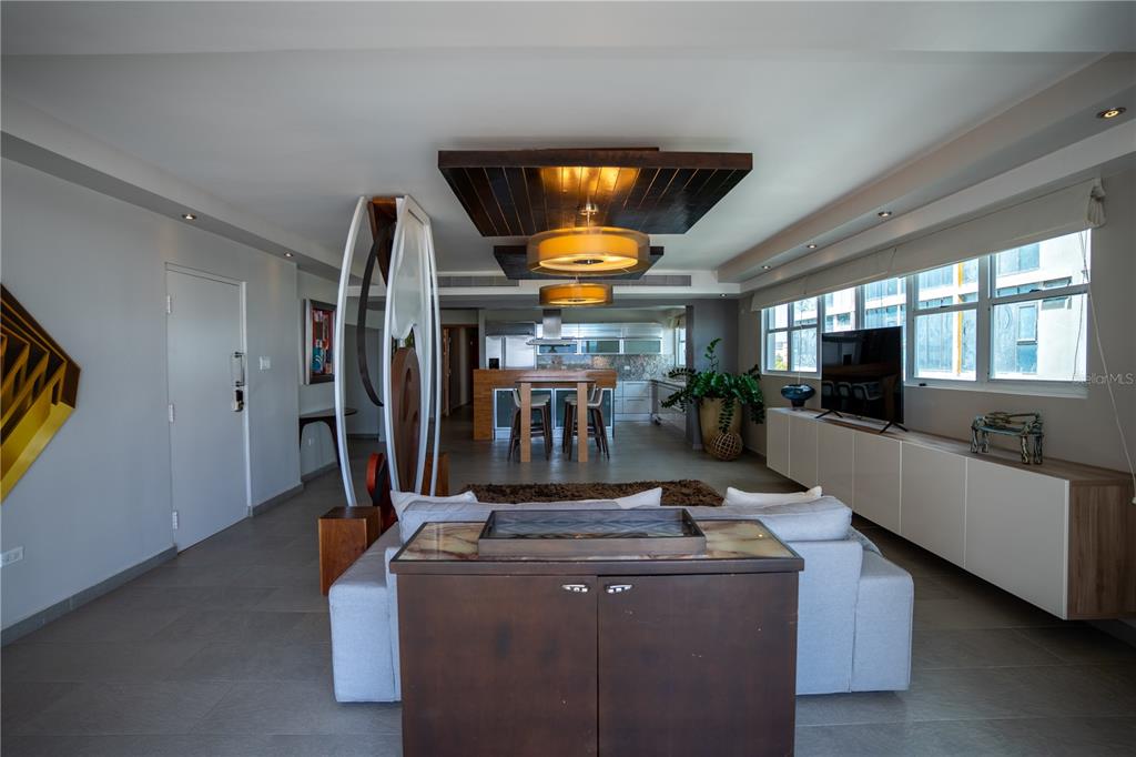 An open-concept living room and kitchen featuring a wooden ceiling feature and modern furniture — 1124 ASHFORD AVENUE UNIT 5B, SAN JUAN, PR
