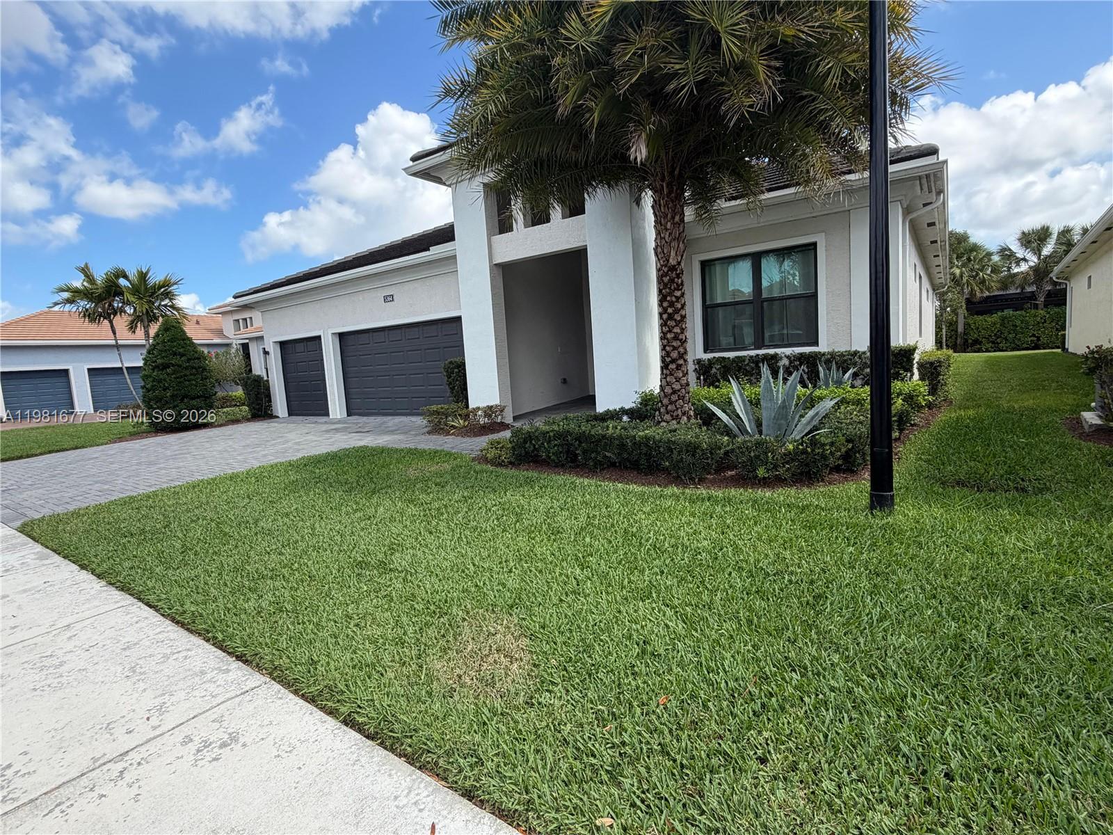 A single-story house features a paved driveway, a two-car garage, and a palm tree — 5364 Siesta Key Ln, Loxahatchee FL 33470, LOXAHATCHEE, FL