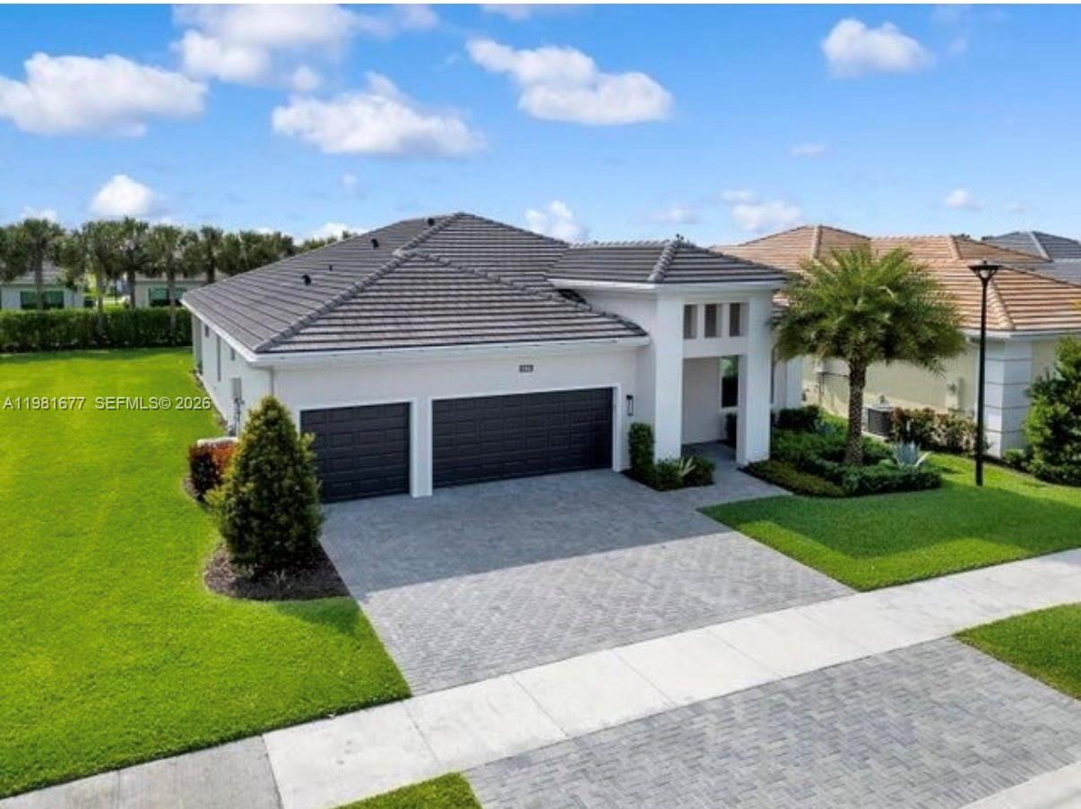 A single-story house with a gray tiled roof, white exterior, and a two-car garage — 5364 Siesta Key Ln, Loxahatchee FL 33470, LOXAHATCHEE, FL