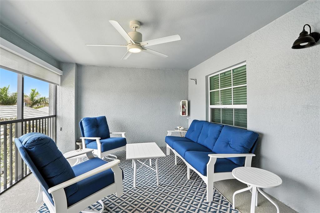 A covered patio features blue furniture, a ceiling fan, and a geometric patterned rug — 14194 HERITAGE LANDING BOULEVARD UNIT 623, PUNTA GORDA, FL