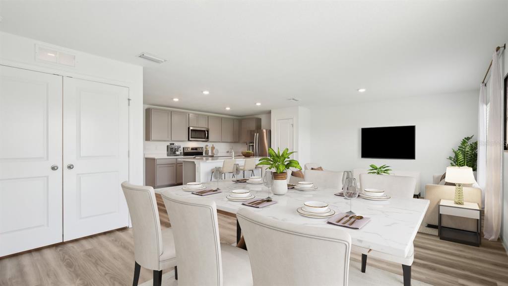 A dining area with a marble-topped table opens into a kitchen with light-colored cabinets — 1011 GUM SPRING COURT, RUSKIN, FL