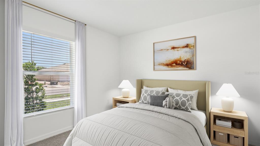 A bedroom features a bed with patterned pillows, two nightstands with lamps, and a window — 1011 GUM SPRING COURT, RUSKIN, FL