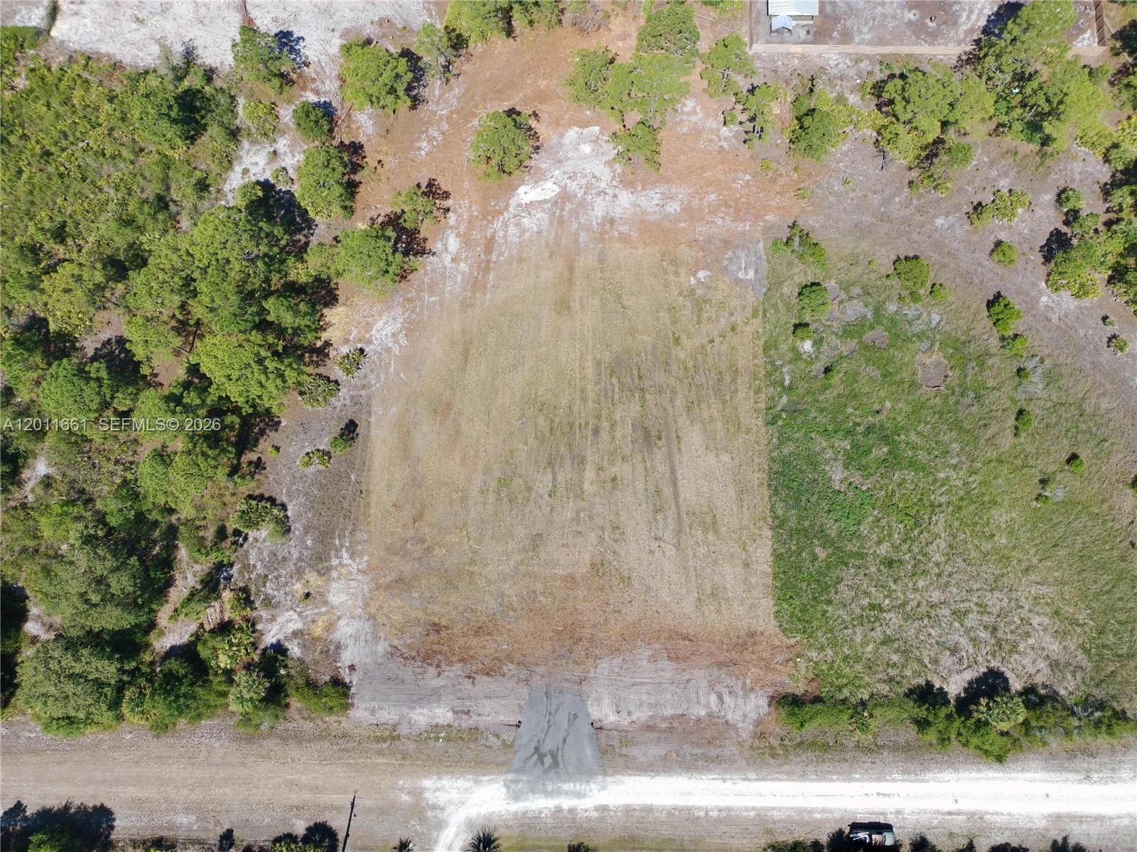 An aerial view shows a cleared rectangular lot bordered by trees and a dirt road — 540 S Zambria ST, Clewiston FL 33440, CLEWISTON, FL