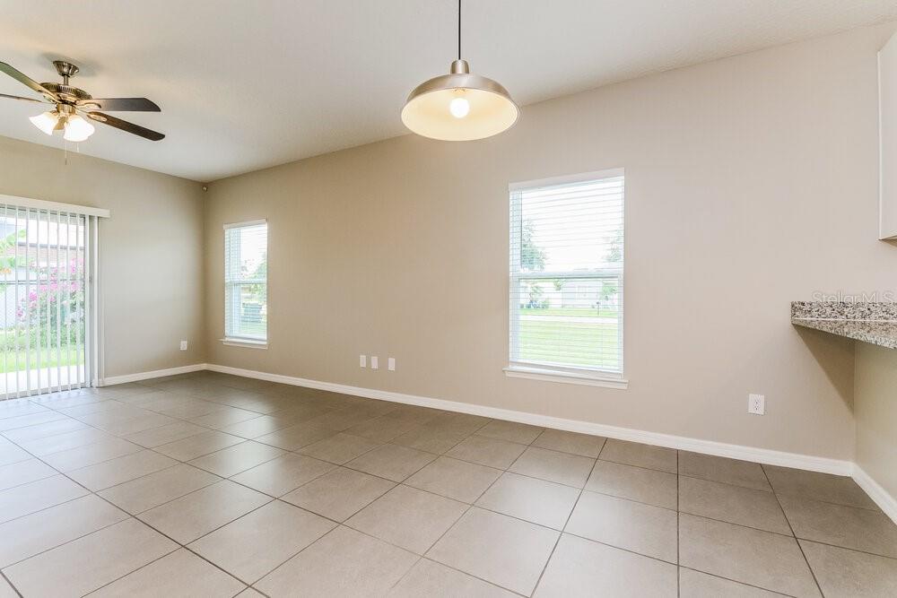 An empty dining area features tile flooring, a ceiling fan, and a pendant light — 126 BRIARCLIFF DRIVE, KISSIMMEE, FL