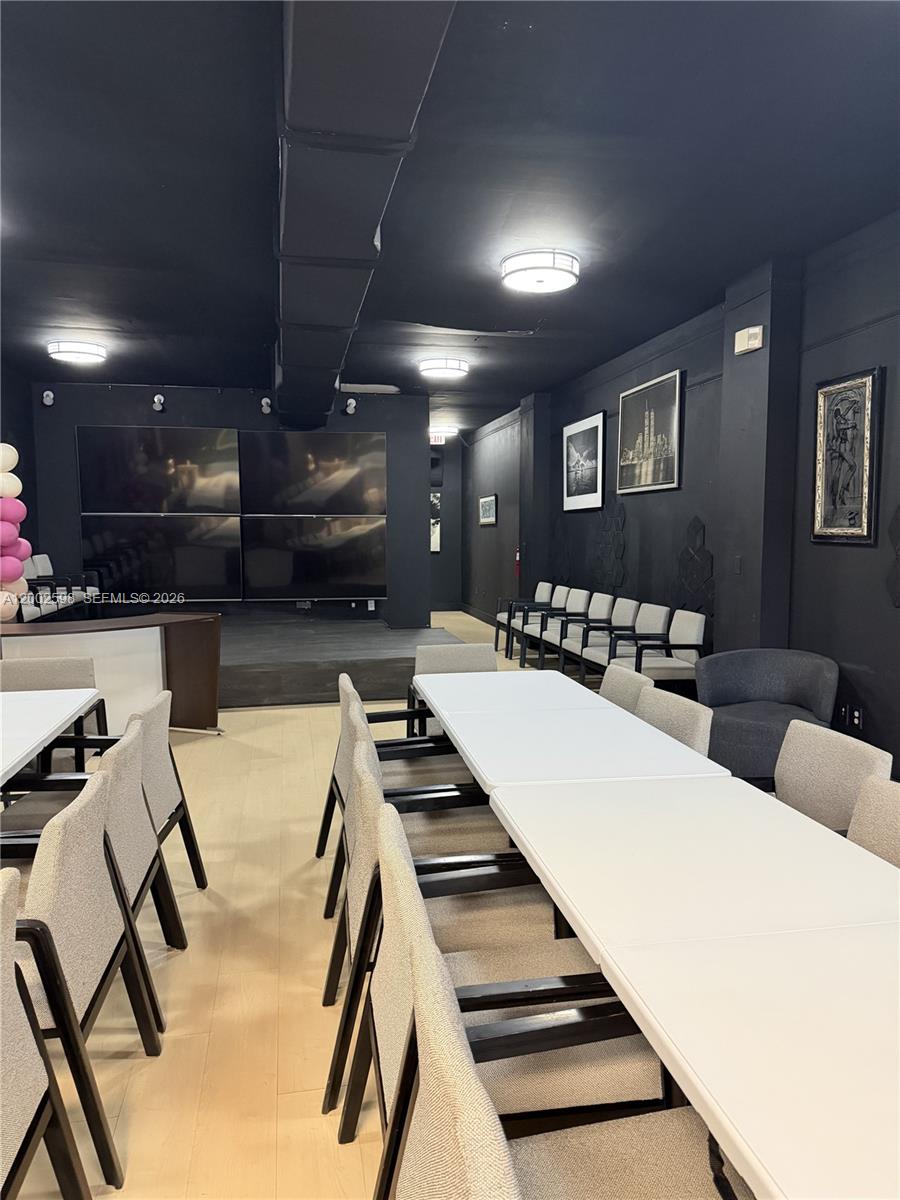 A room with black walls and ceiling features rows of tables, chairs, and a stage — 519 S 21st Ave, Hollywood FL 33020, HOLLYWOOD, FL