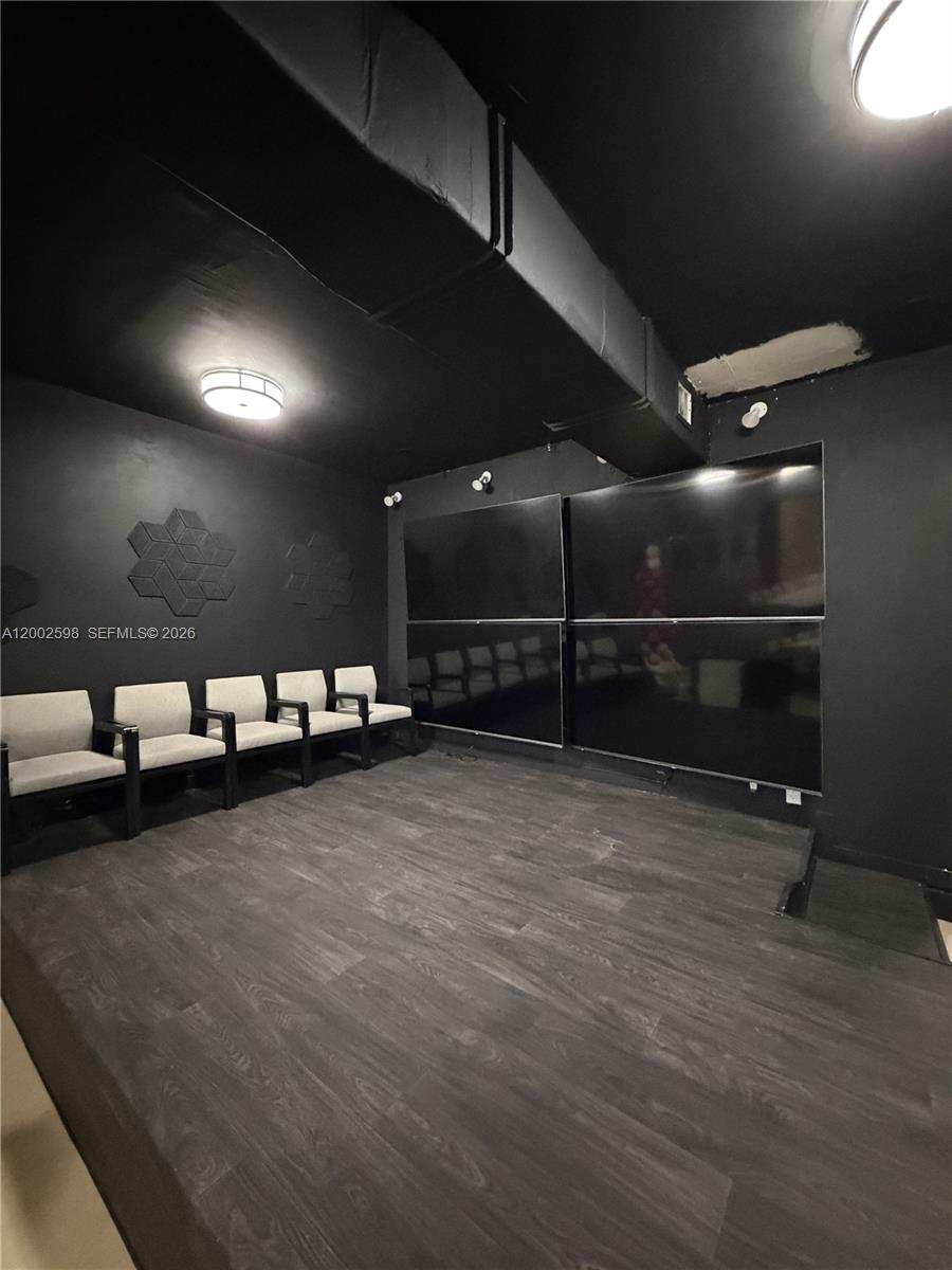A home theater room features black walls, dark wood flooring, and a four-screen wall display — 519 S 21st Ave, Hollywood FL 33020, HOLLYWOOD, FL