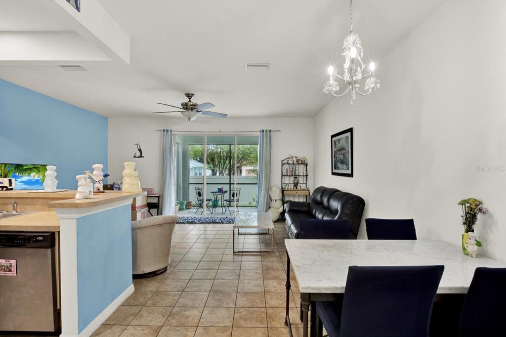 A living and dining area features tile floors, a ceiling fan, and a sliding glass door — 6843 46TH LANE N, PINELLAS PARK, FL