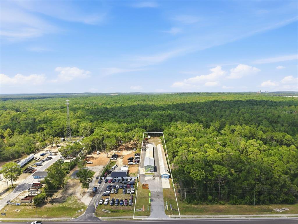 An aerial view shows a narrow commercial property with two long buildings and parking — 16331 CORTEZ BOULEVARD, BROOKSVILLE, FL