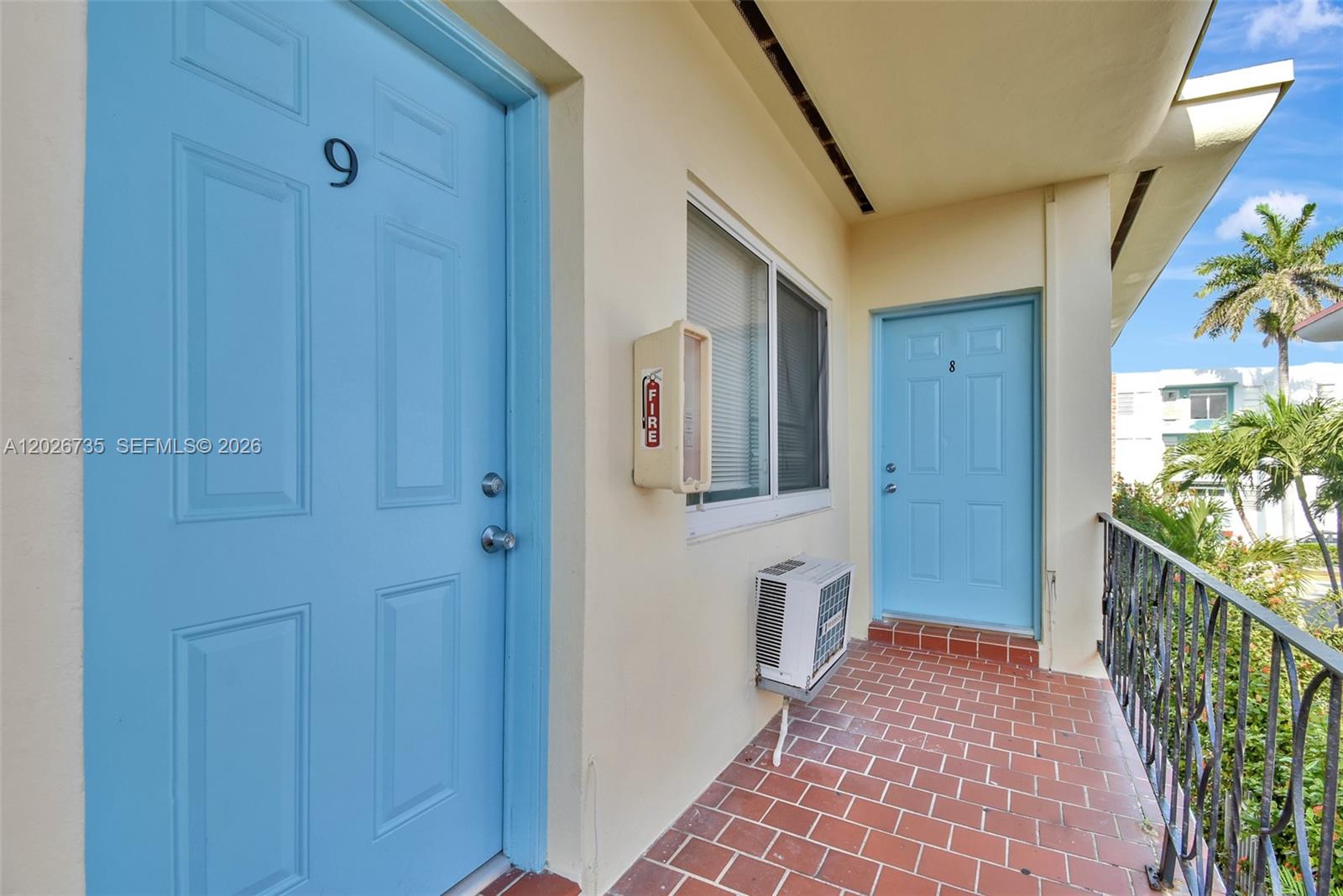 An exterior walkway features two light blue doors numbered eight and nine with red tile flooring — 1135 Euclid Ave # 202, Miami Beach FL 33139, MIAMI BEACH, FL