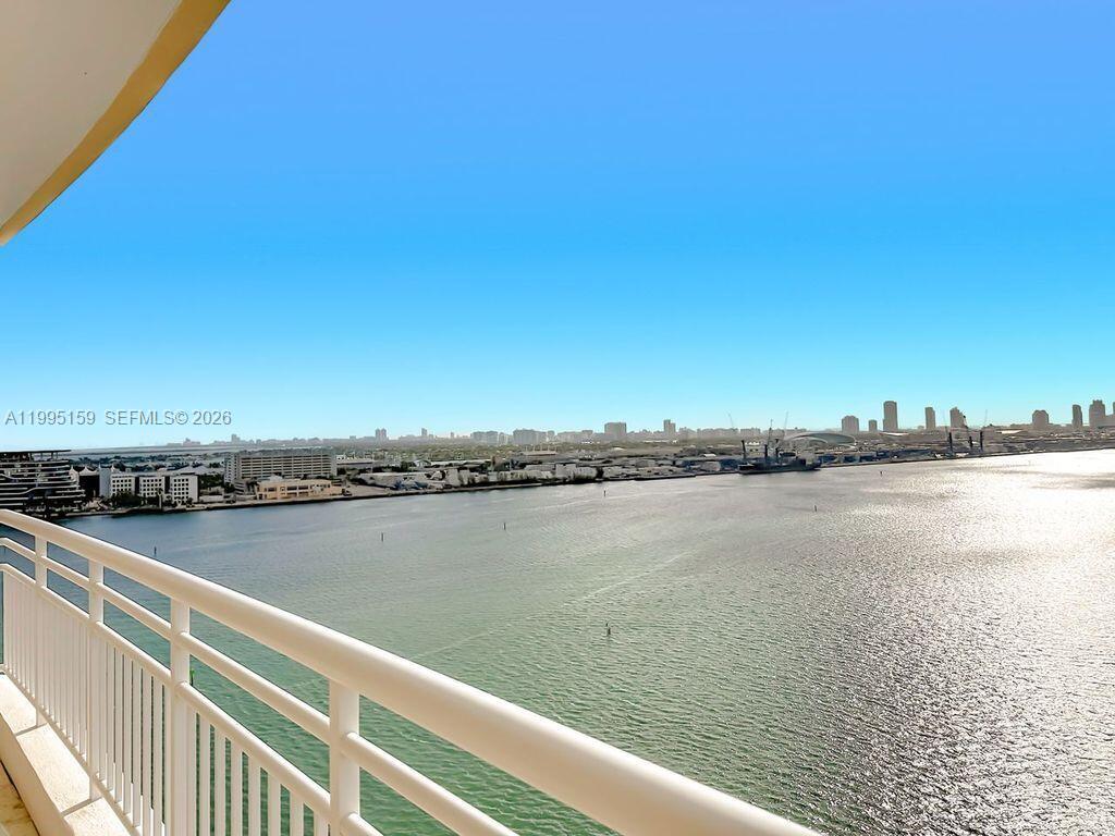 A balcony overlooks a wide body of water with a distant city skyline — 808 Brickell Key Dr # 2002, Miami FL 33131, MIAMI, FL